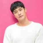 sung hoon behind a pink back-drop